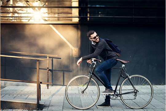 スポーツミックスコーデで自転車に乗る外国人男性