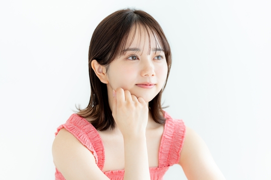 右肘をついて遠くを見る女性
