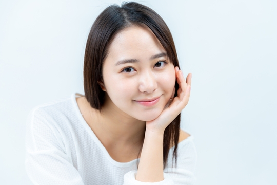 左肘をついてこちらを見る女性