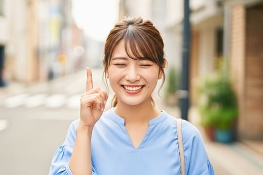 右人差し指で上を指している女性