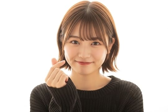 指ハートを作っている女性